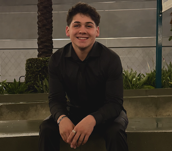 Finn Smith smiling sitting with hands together on knees