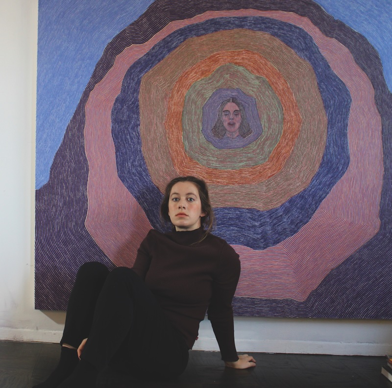 Brittany Miller in front of her artwork