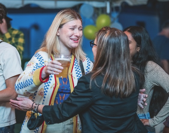 alumni drinking and hugging