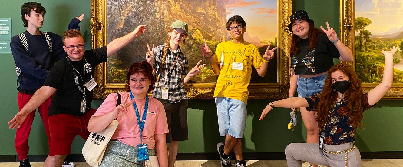 group of students posing in front of artwork