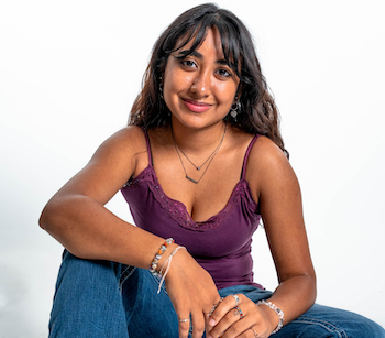 Taarena Rathore with arms leaned on legs smiling 
